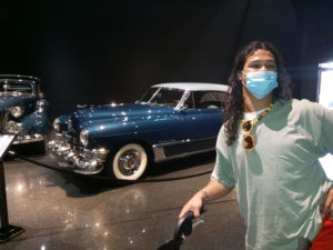 Mikey standing in front of an old Cadillac car at the Blackhawk Museum