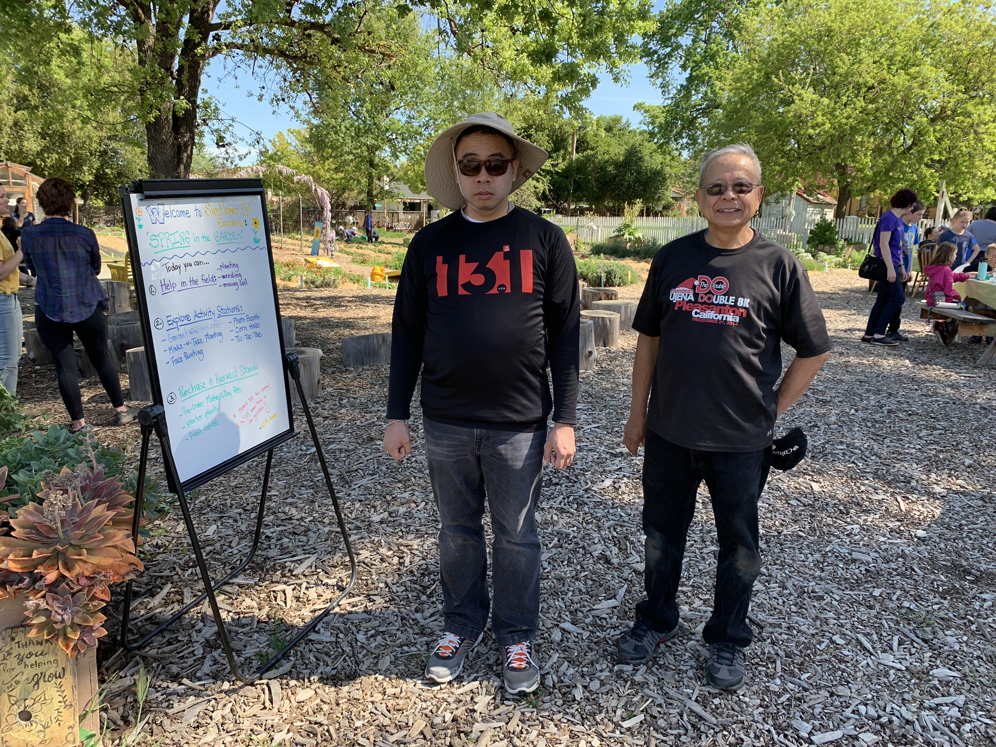 David and Angel standing near an easel at the Sunflower Hill Garden.