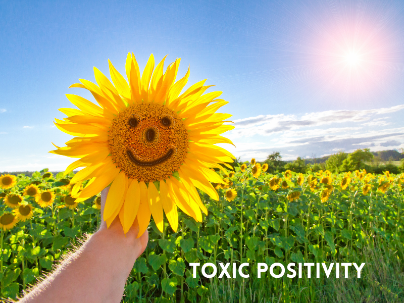 Sunflowers in a field and hand holding a sunflower with smiley face. Caption: Toxic positivity