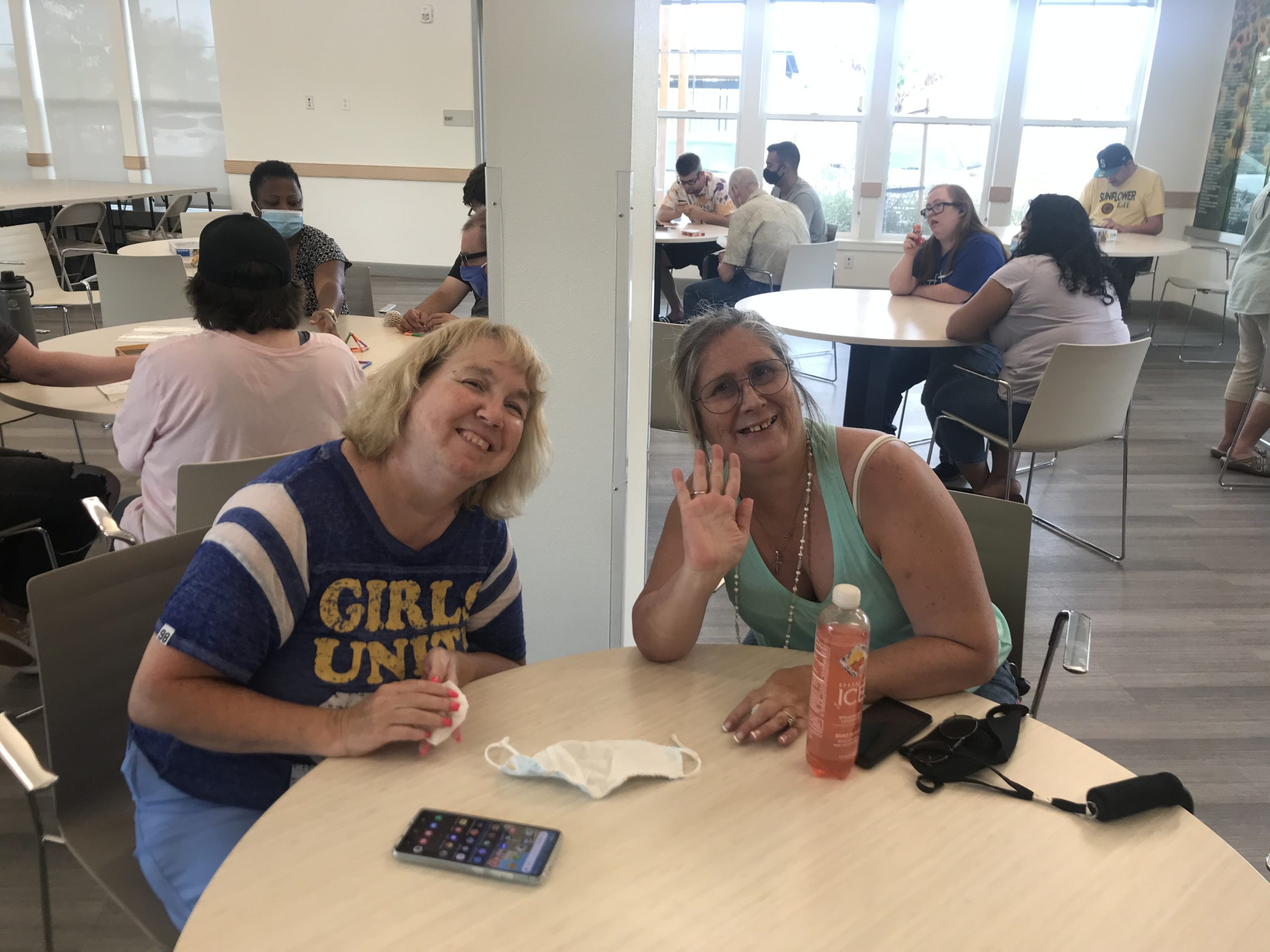 Della and her friend sitting at a table in the Irby Ranch community room.