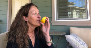 Edie smelling a fresh-cut lemon