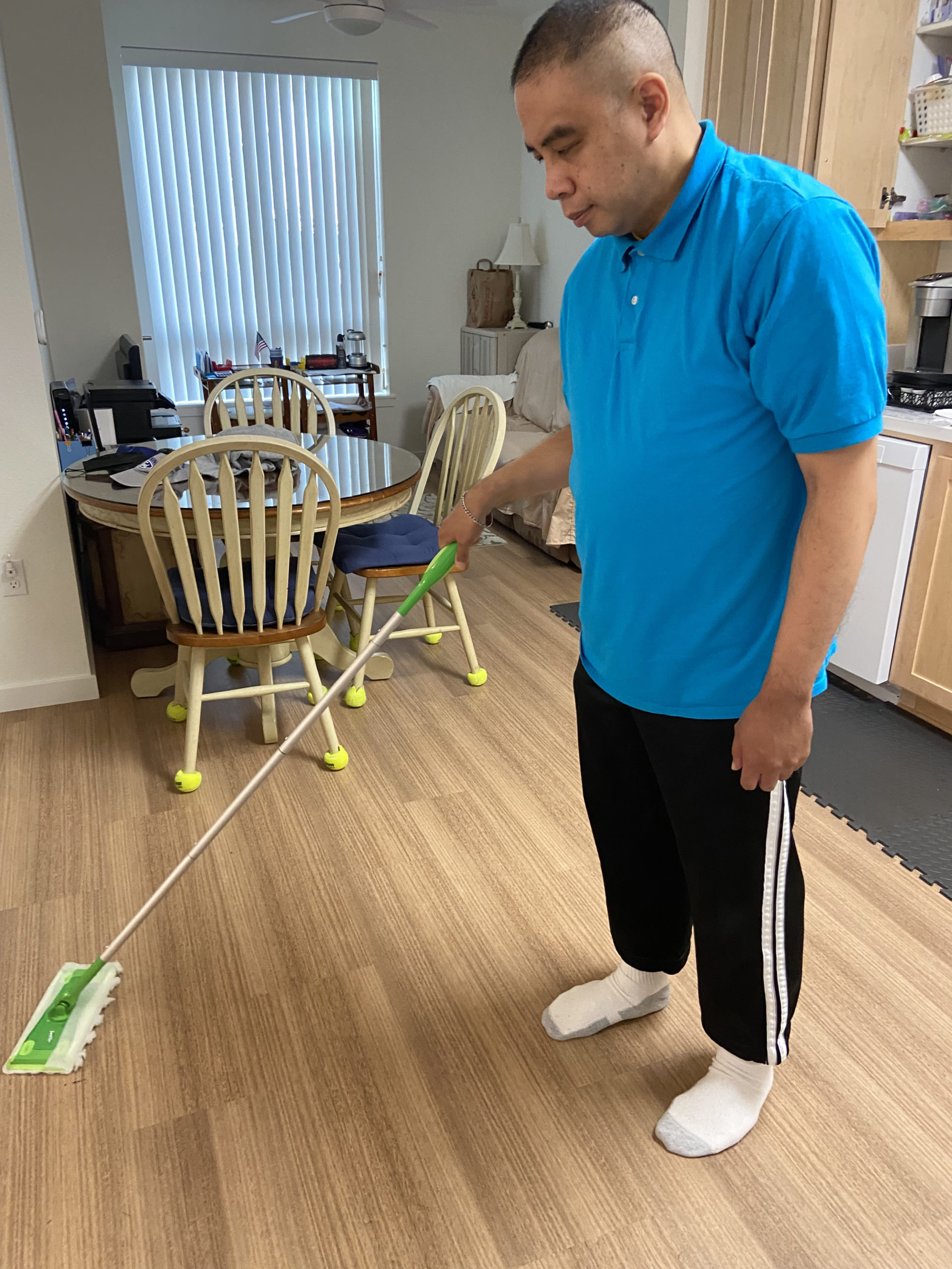 David with a swiffer, mopping his kitchen floor.