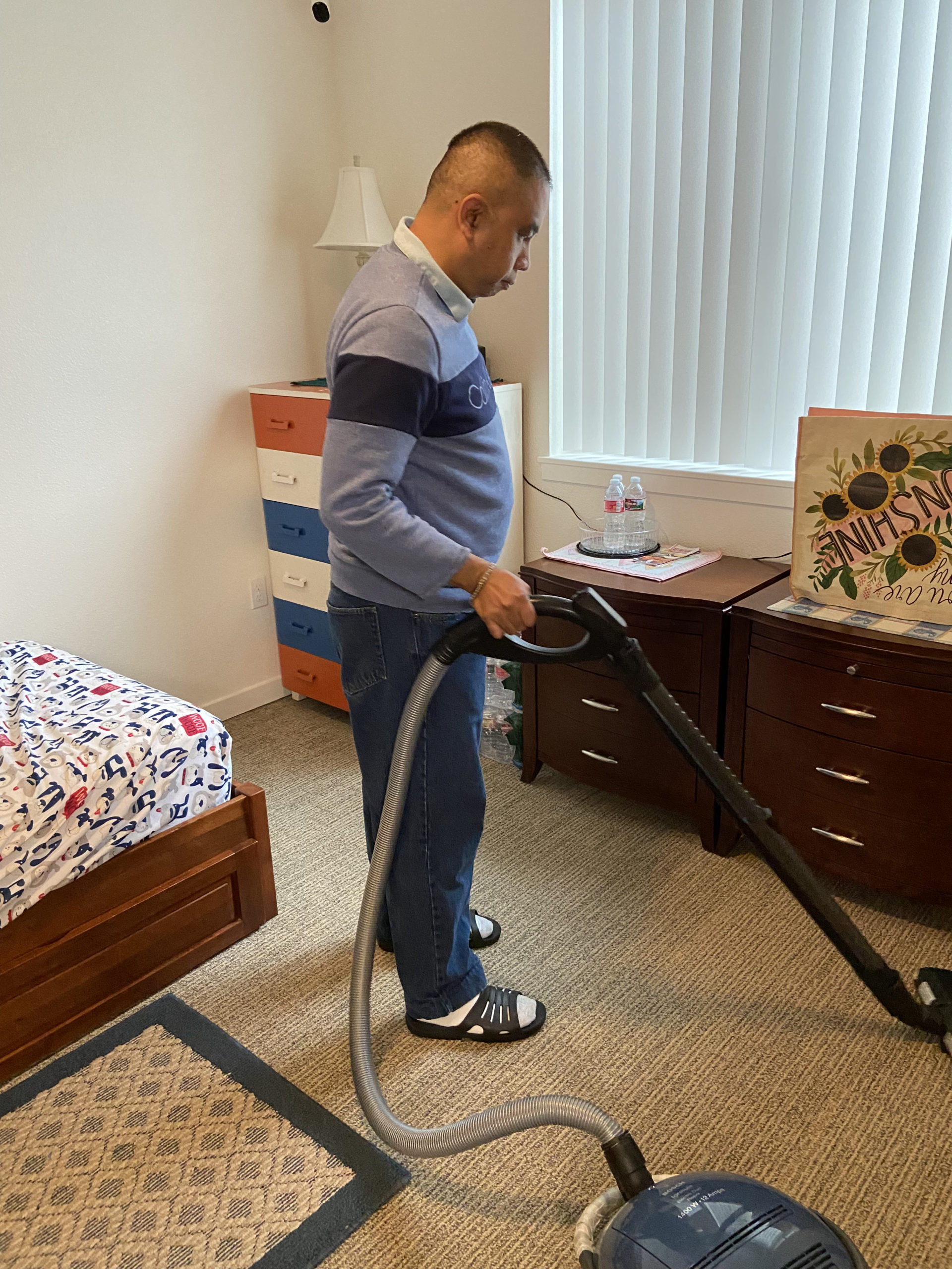 David vacuuming his bedroom.
