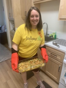 Jennifer holding a tray of enchiladas she baked in her apartment