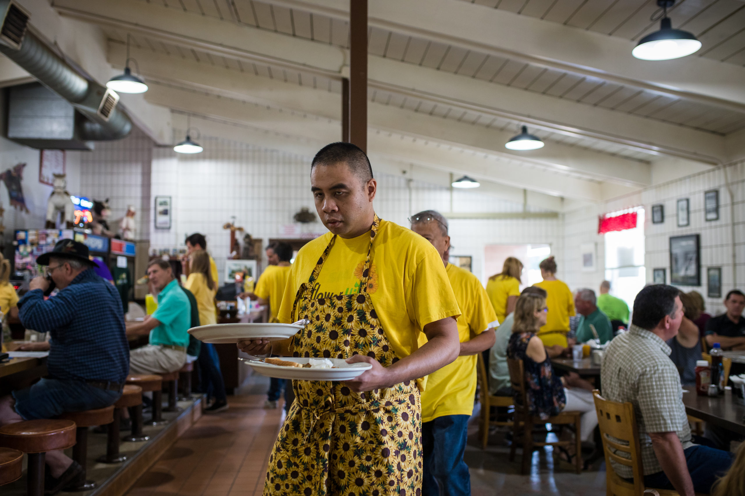 David holding dishes as he clears a table at the Stable Cafe restaurant.
