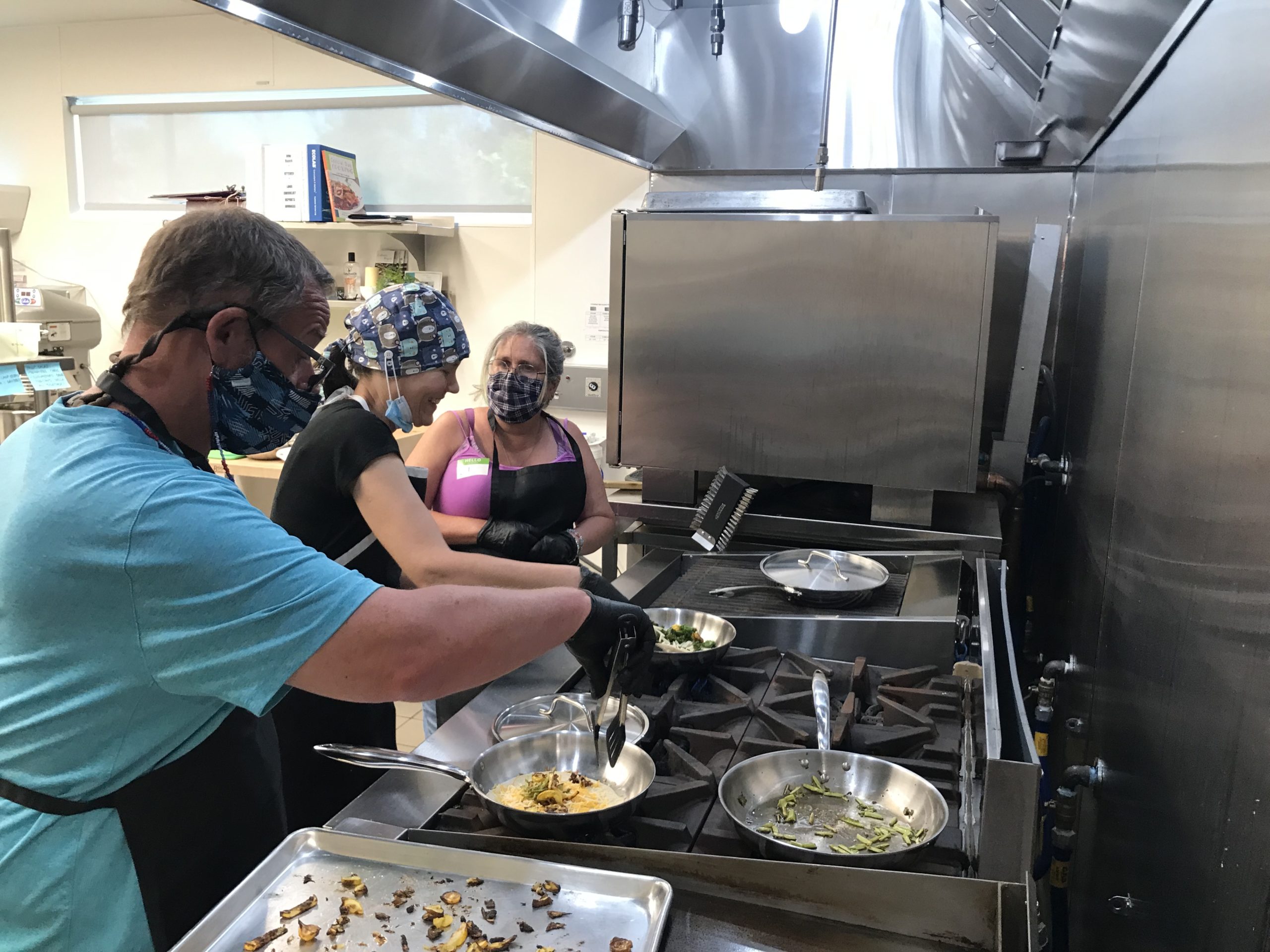 Della standing next to a stove talking with Chef Claudia.