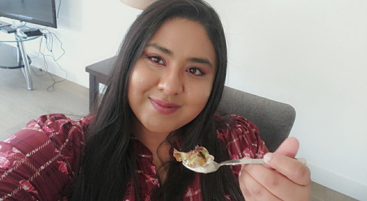 Pratima holding a spoon full of banana bread and ice cream