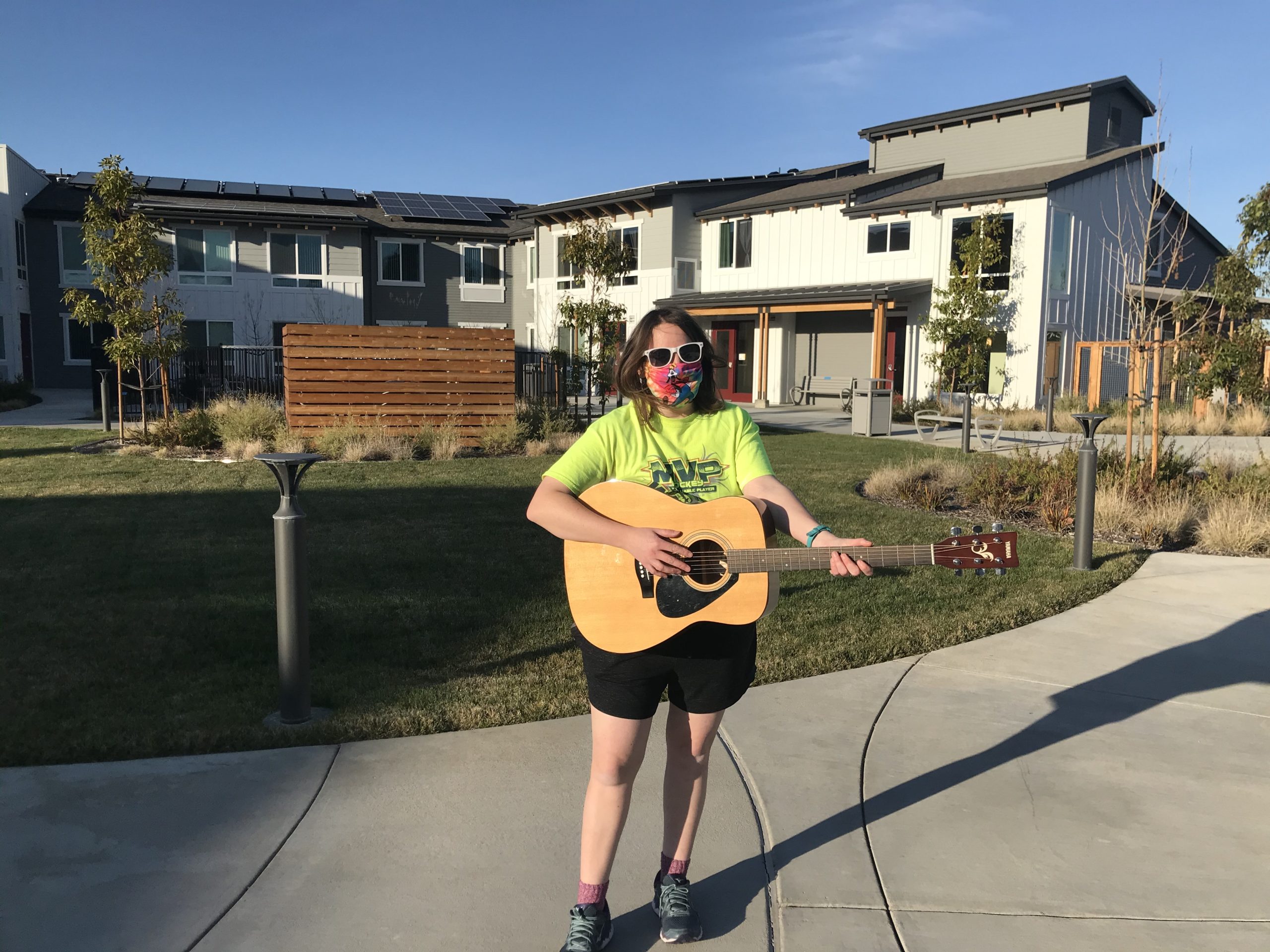 Jennifer playing a guitar in the Irby Ranch courtyard