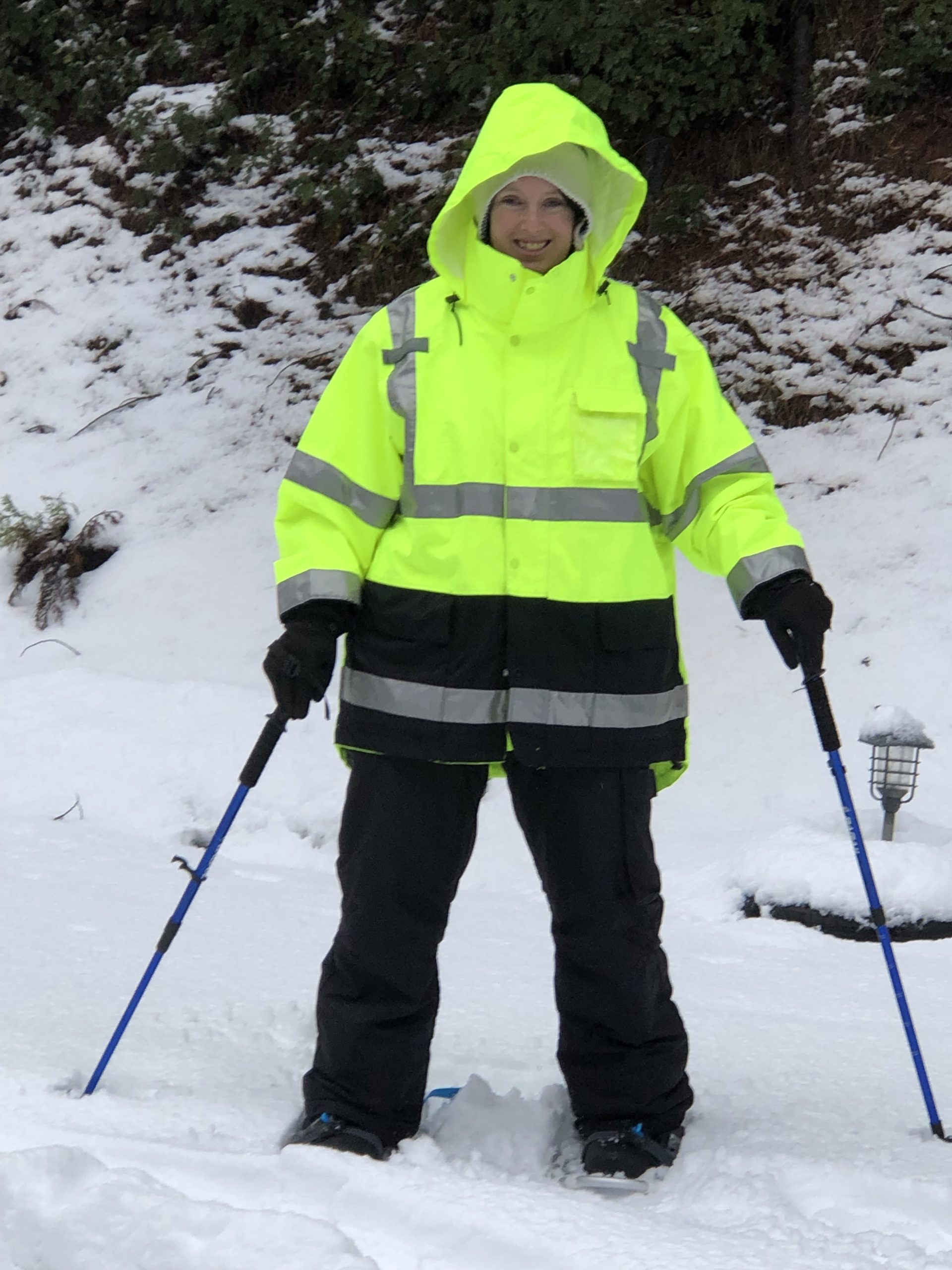 Jennifer standing in snow with ski poles.