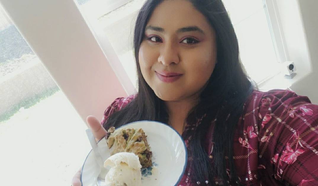 Pratima holding a plate with banana bread and ice cream