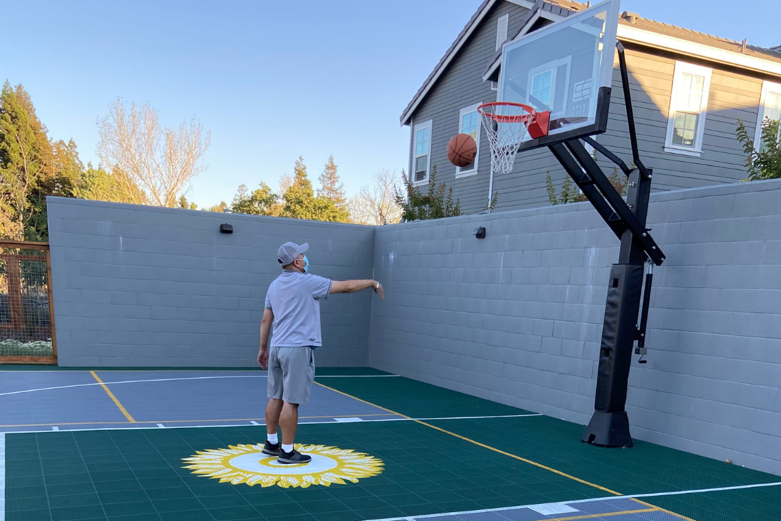 David tossing a basketball toward the hoop on the Irby Ranch Sports court