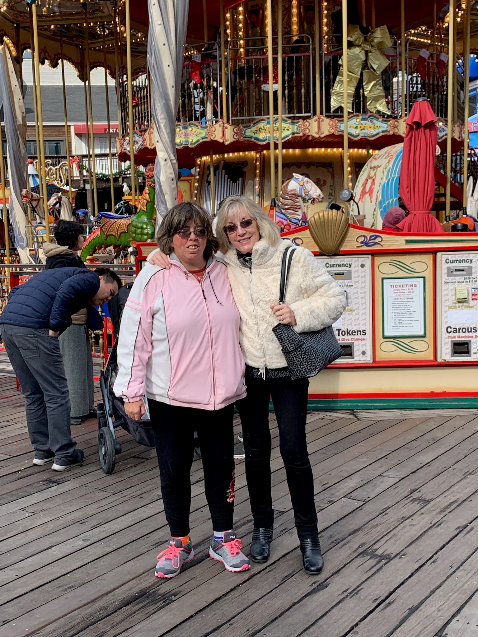 Shannon and her mom standing in front of a carousel 